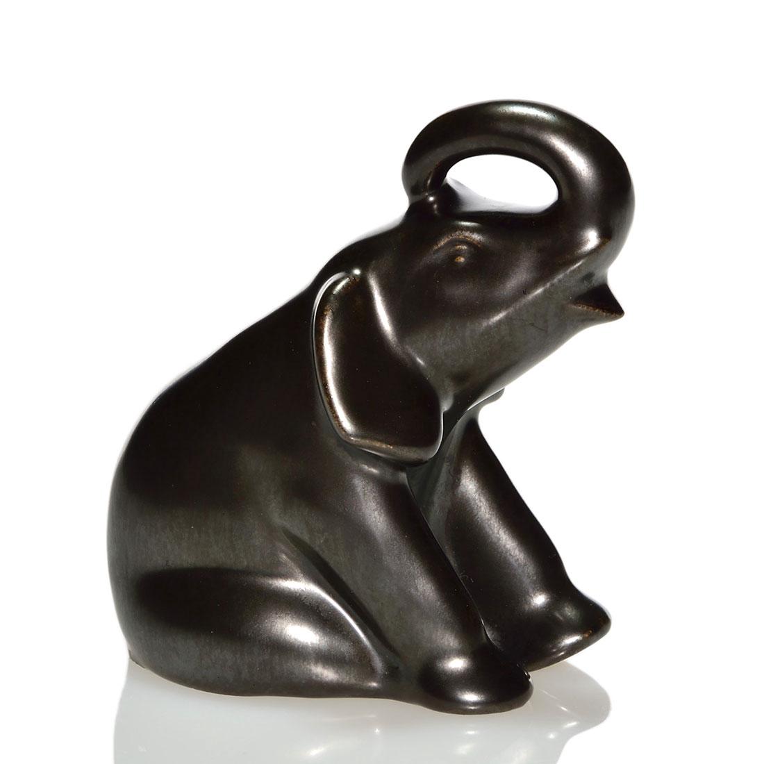 Rookwood Elephant paperweight, Nubian Black,1951, 3 7/8: Baby elephant paperweight, cast in 1951 and covered with the Nubian Black glaze. Marks include the Rookwood logo, date and shape 6490. There is a tiny nick at the base. Height is 3 7/8 inches.