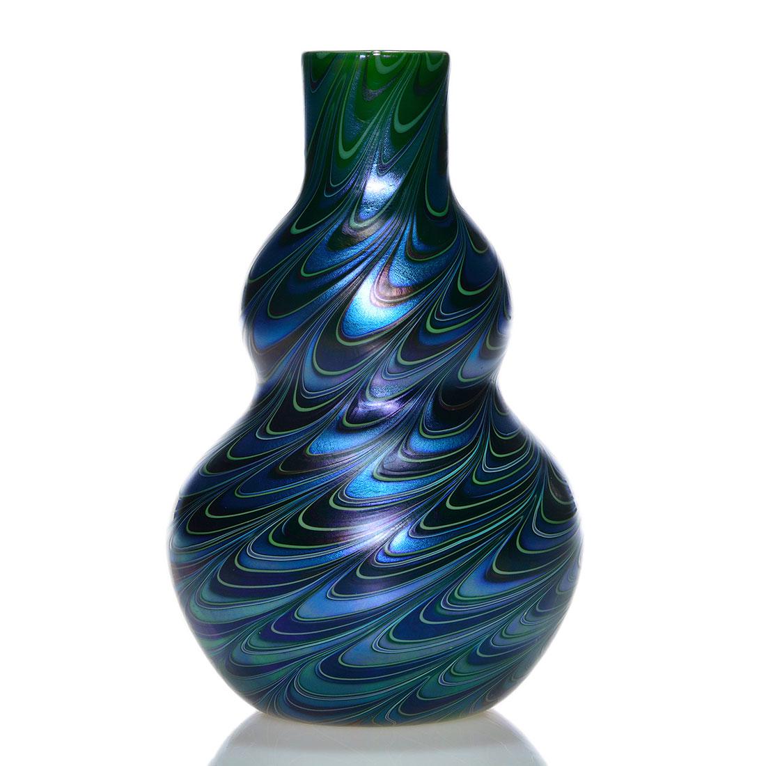 Orient & Flume double gourd vase, spiral loops, 8 1/2",: Early Orient & Flume double gourd vase revealing a spiral drag loop design in aurene blue, ebony and green. Height 8 1/2 inches. Engraved Orient & Flume, 1981M104. Button pontil. A tight line crosses