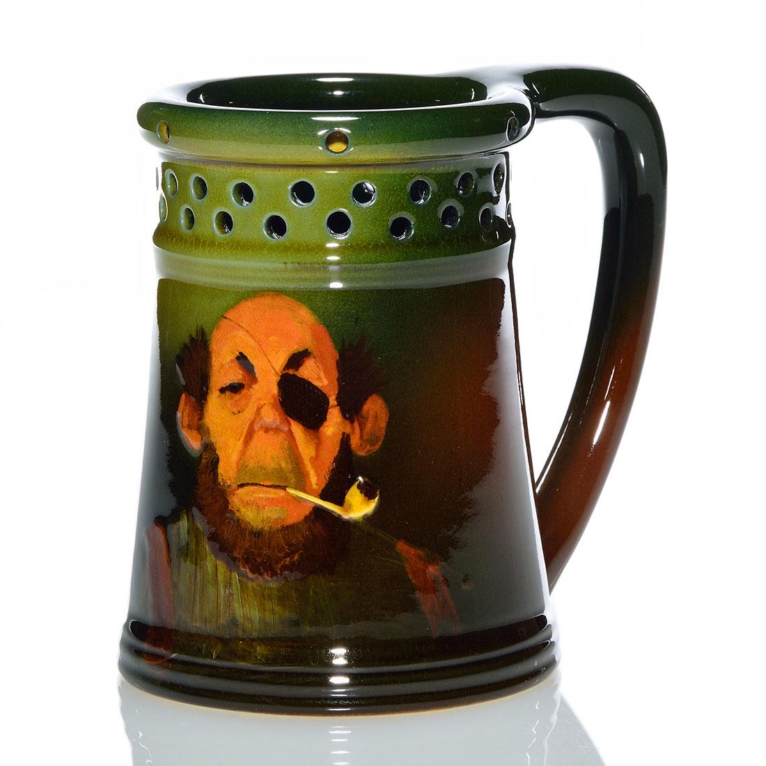 Rookwood Standard Puzzle Mug, Horsfall, 1894, 711, 5": Standard glaze puzzle mug decorated with a bearded man with an eye patch, smoking a pipe, the work of Bruce Horsfall in 1894. Marks include the Rookwood logo, which indicates the date, shape 711 and M