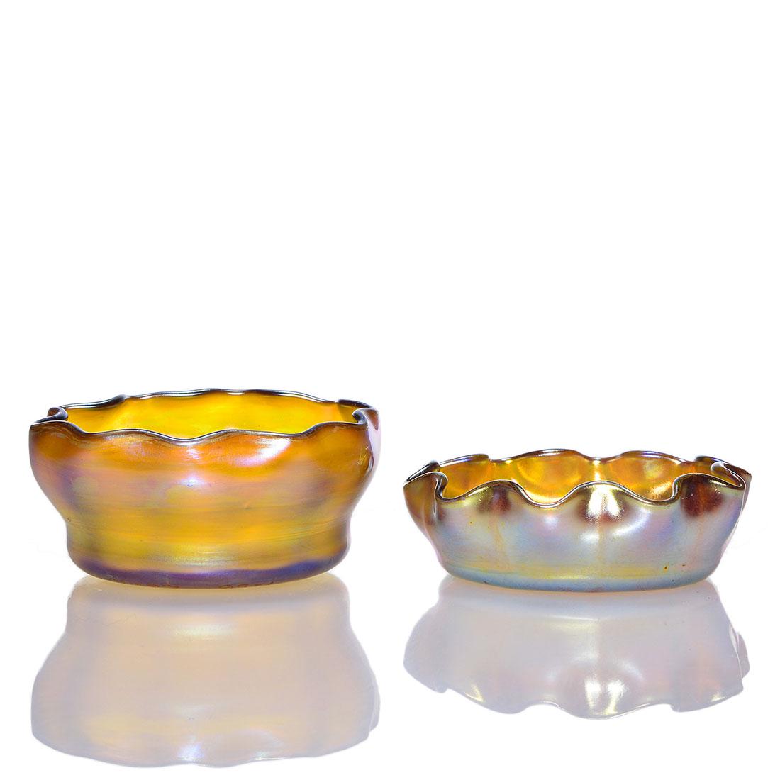 2 Tiffany Favrile salt cellars, gold, signed, 1256: Two Tiffany Favrile gold salts with ribbed bodies and scalloped rims. 1) Engraved 1256 L.C.Tiffany Favrile, measures 1 1/4 inches by 2 7/8 inches across. Bronzy color. 2) Engraved L.C.T. Favrile, meas