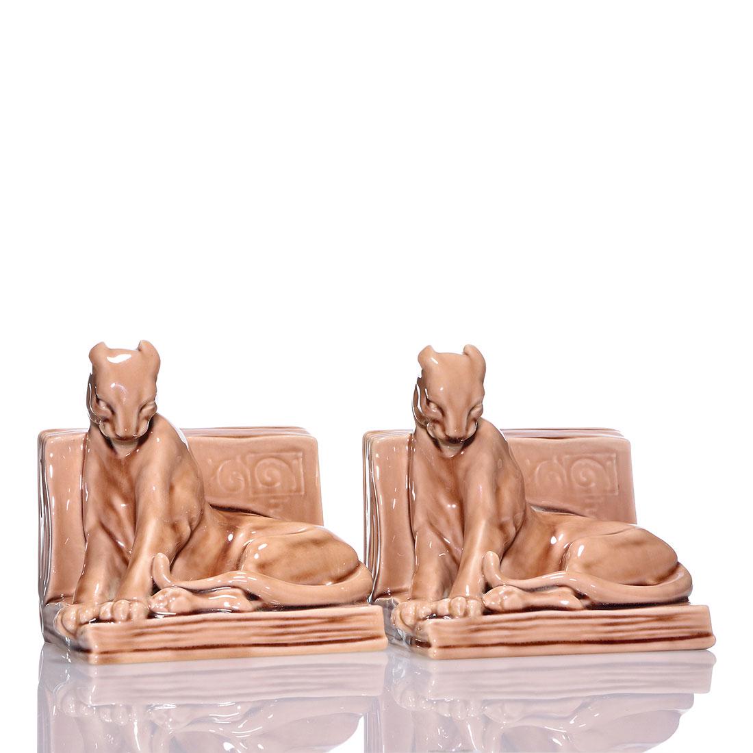 Rookwood Panther bookends, 1953, 2564, 5 5/8": Pair of Panther bookends, a William McDonald design, cast in 1953 and covered in the Wine Madder glaze. Marks include the Rookwood logo, date, shape 2564 and Mr. McDonald's mold monogram. One has craz