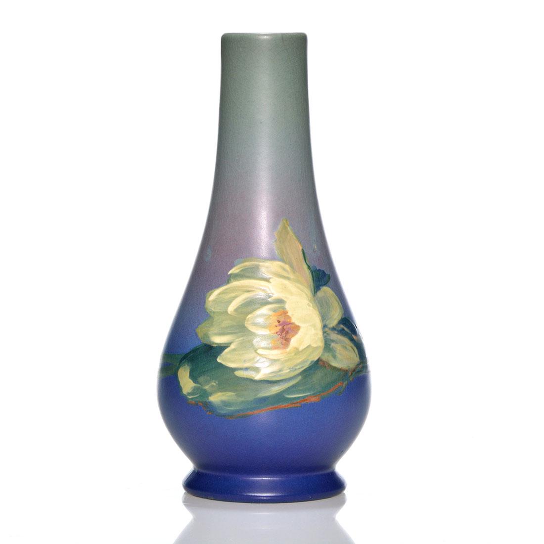 Weller Hudson vase, water lily, 10 1/2", Leffler: Weller Hudson vase displaying a water lily painted by Claude Leffler, his signature on the base. Height 10 1/2 inches. Impressed Weller. Two hairlines descend the rim. Fine crazing. Well detailed flow