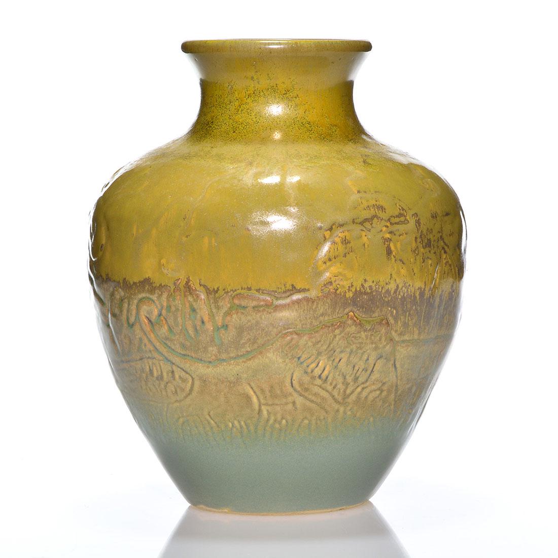Red Wing Lion vase, Nokomis glaze, 10 1/4": Early Red Wing vase with embossed scene of lions in a jungle setting. The vase has the Nokomis glaze round the neck and rim and then a soft brown over gray mat finish on the rest. Marked with the circ