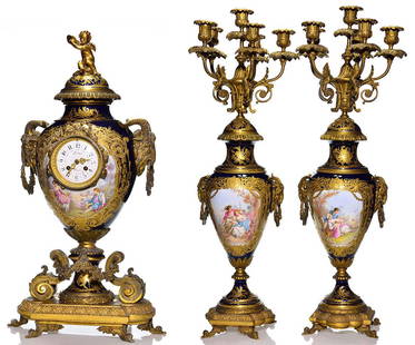 Majestic Sevres gilt bronze porcelain clock, urns, 30": Exceptional Sevres Louis XV style Bleu-du-Roi mantel clock and matching pair of candelabrum gilt bronze garniture set. The bolted porcelain clock and bolted porcelain candelabrums depict courting scen