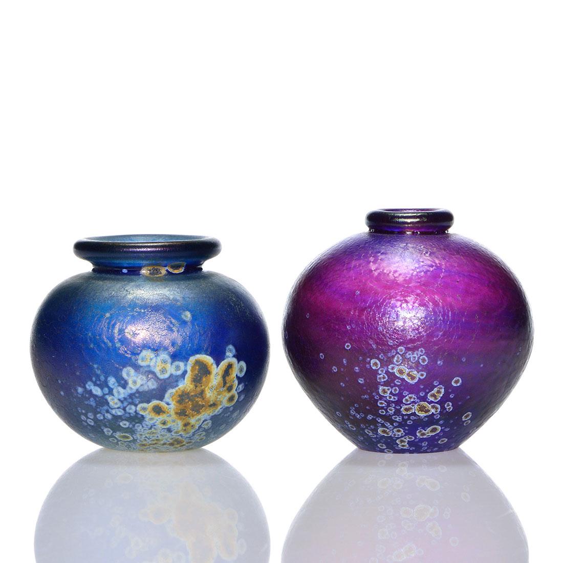 2 early Mark Peiser miniature vases, 1969, 2 5/8": Two early Mark Peiser miniature vases consisting of a 2 5/8 inch amethyst and a 2 1/4 inch royal blue. Both have sprayed mineral patterns over the textured surfaces and are engraved Mark Peiser 1969.
