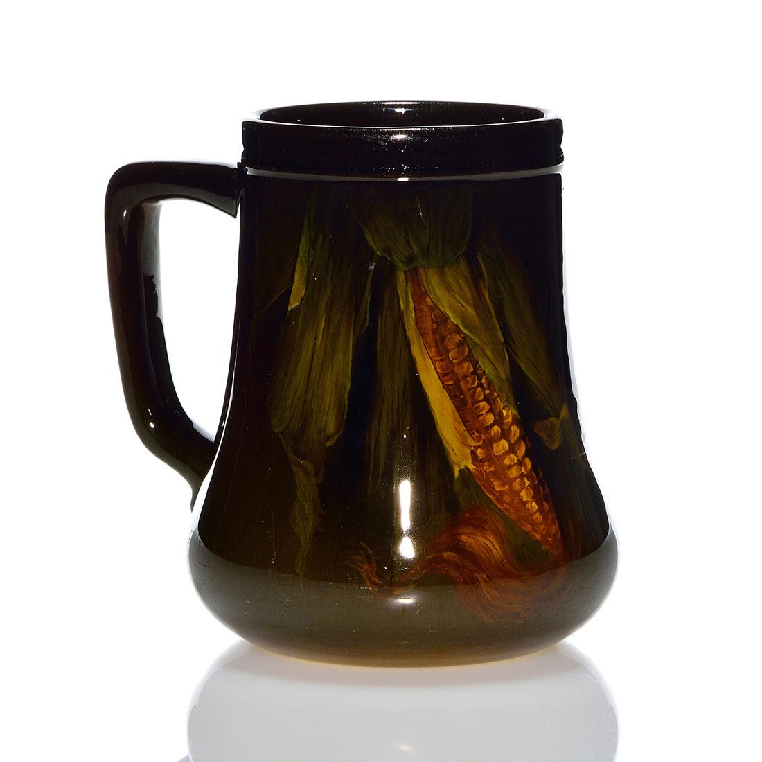 Rookwood Standard mug, corn, Rothenbusch, 1899, 5”: Standard glaze mug decorated with ears of corn painted by Fred Rothenbusch in 1899. Marks include the Rookwood logo, which indicates the date, shape 656 and the artist’s incised monogram. There 