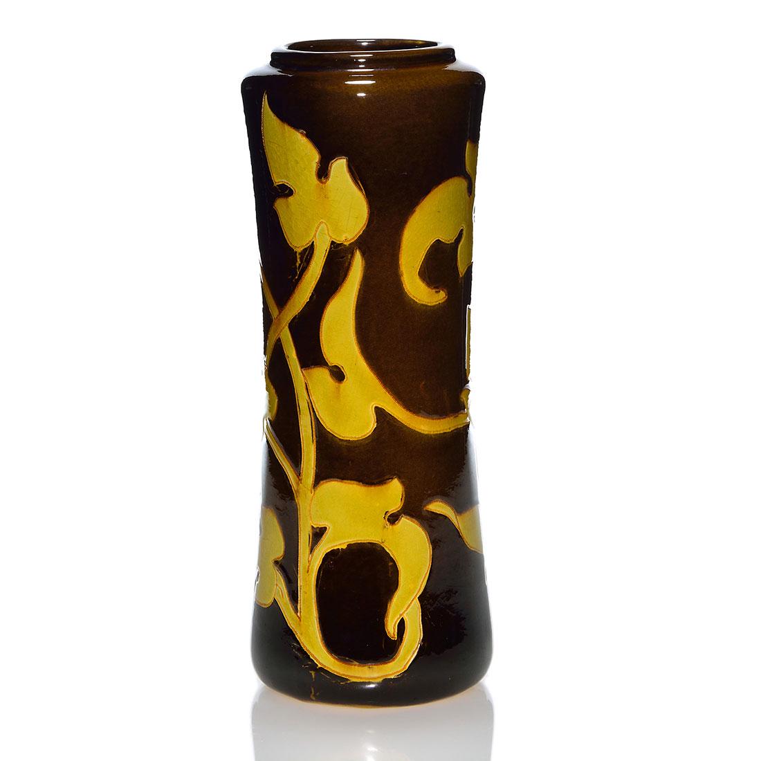 Weller Dickens Ware vase, leaves, Ferrell, 11 3/4”: Weller Dickens Ware vase likely done by Frank Ferrell with incised leaves and stems glazed in yellow against a dark brown ground. Impressed Dickens Ware Weller 581 4 on the bottom. There is fine overa