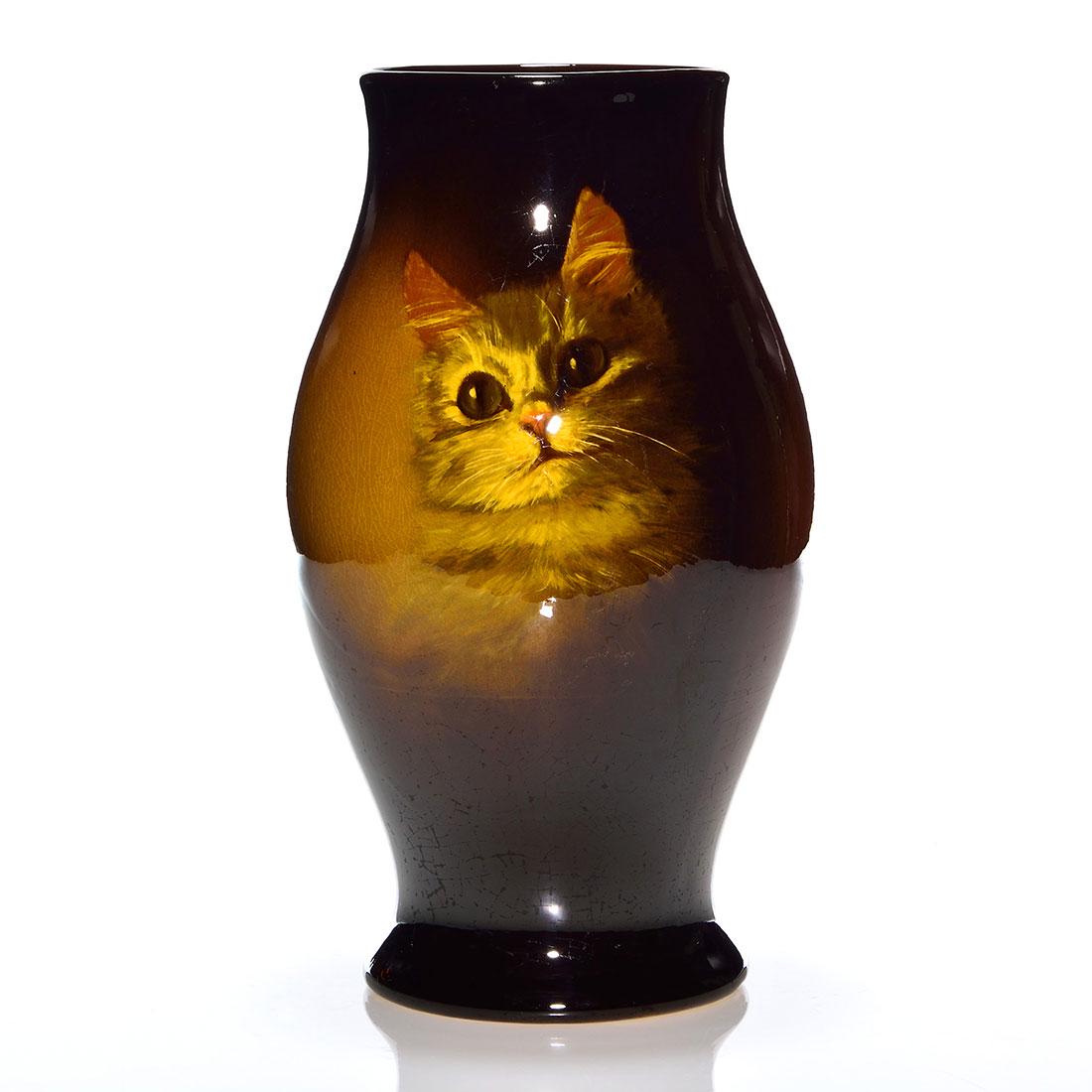 Owens Utopian vase, kitten, Timberlake, 11 7/8”: Owens Utopian vase displaying the head of a kitten painted and signed by Mae Timberlake. Height 11 7/8 inches. Impressed Owens Utopian 1038 beneath. Fine overall crazing. Elizabeth Rudisill Collection