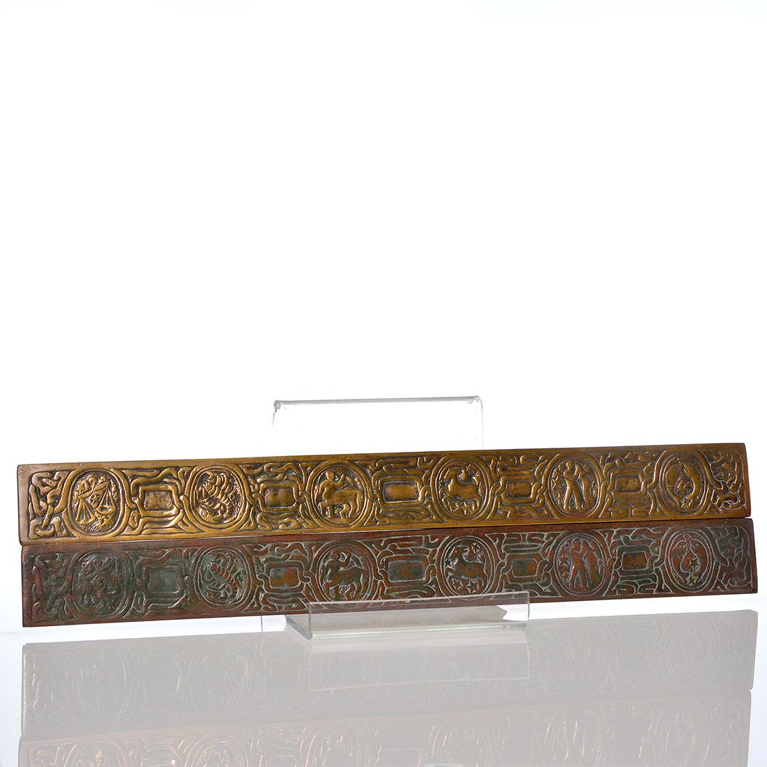 Pr Tiffany Studios Zodiac blotter ends, 19 1/4": Large pair of Tiffany Studios Zodiac blotter ends, 19 1/4 inches in length, each impressed Tiffany Studios, New York, 988. One blotter has been cleaned and shows mild oxidation recovery. The other blo