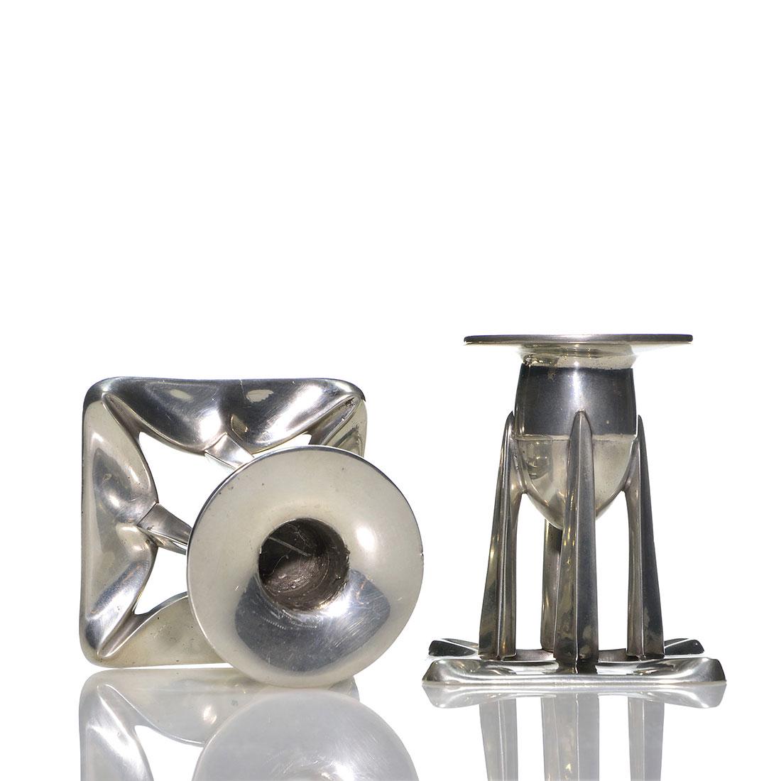 English Pewter A&C pillared candleholders, 3 3/4”: Pair Arts & Crafts English pewter candleholders, a futurist design rising 3 3/4 inches. Impressed English Pewter 0222. Deep scratches inside the holders.
