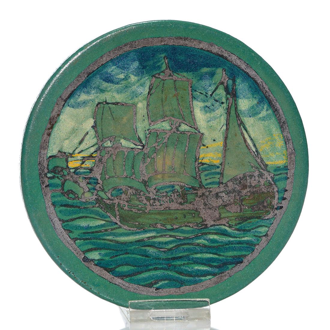 SEG Paul Revere trivet, Galleon, 11-23, 5 3/4”: Saturday Evening Girls trivet decorated with the image of a Galleon done in mat glazes. Marked on the back S.E.G. and 11-23 in black slip and having most of an original Paul Revere Pottery price stick