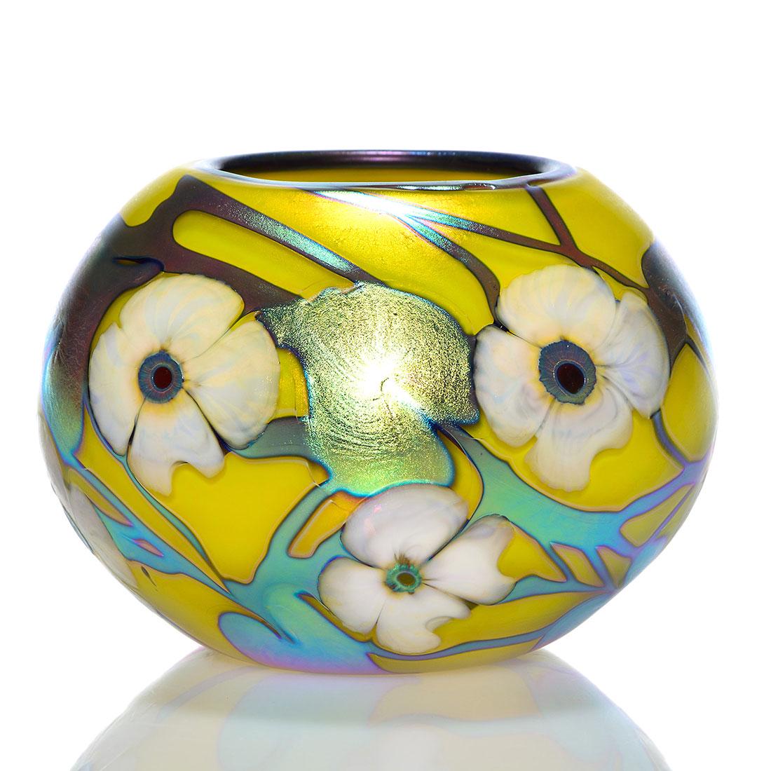 Charles Lotton Mandarin yellow bowl, white Multi,5": Mandarin Yellow Multi Flora vase created by Charles Lotton in 1994. Eight white blossoms are perfectly arranged upon bright aurene blue vines with foliage and enclosing the rim with an an aurene blue 