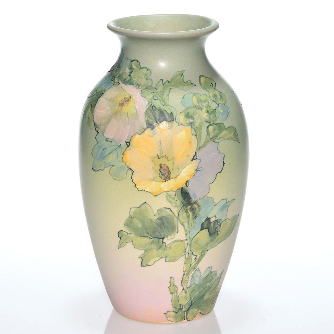 Weller Hudson vase, hollyhocks, England, 11 7/8”: Weller Hudson vase decorated with hollyhocks by Dorothy England who signed in black slip near the base. Marked with the Weller Ware full kiln ink stamp and impressed WELLER on the bottom. Uncrazed wit
