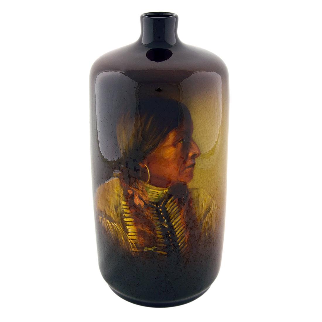 Owens Utopian Indian portrait, Timberlake, 10 1/2”: Owens Utopian vase decorated with the portrait of a Native American decorated and initialed by Mae Timberlake in slip near the bottom of the vase. Impressed Owens, Utopian, shape 1010 and B.O. on the 