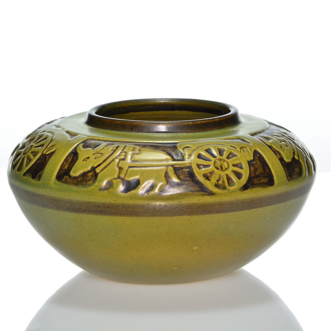 UND Ox Cart vase, 3 1/2”, Huckfield: UND shouldered vase with oxen pulling a cart within four panels based on a Flora Huckfield design and covered in avocado and dark brown glazes. Measures 3 1/2 inches by 6 3/4 inches across. Incised Re