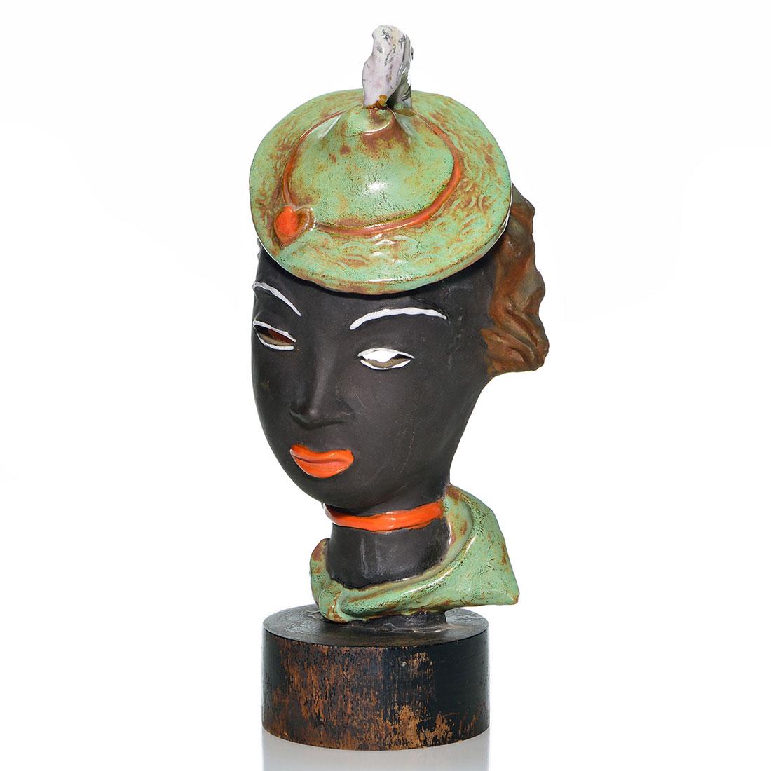 Czech ceramic figure, classy black female head, 11 7/8: Czechoslovakia ceramic head of a classy black female with cut out eyes, pouty orange lips and wearing a feathered cap. Impressed Made in Czechoslovakia and stamped Foreign and mounted within a blacken