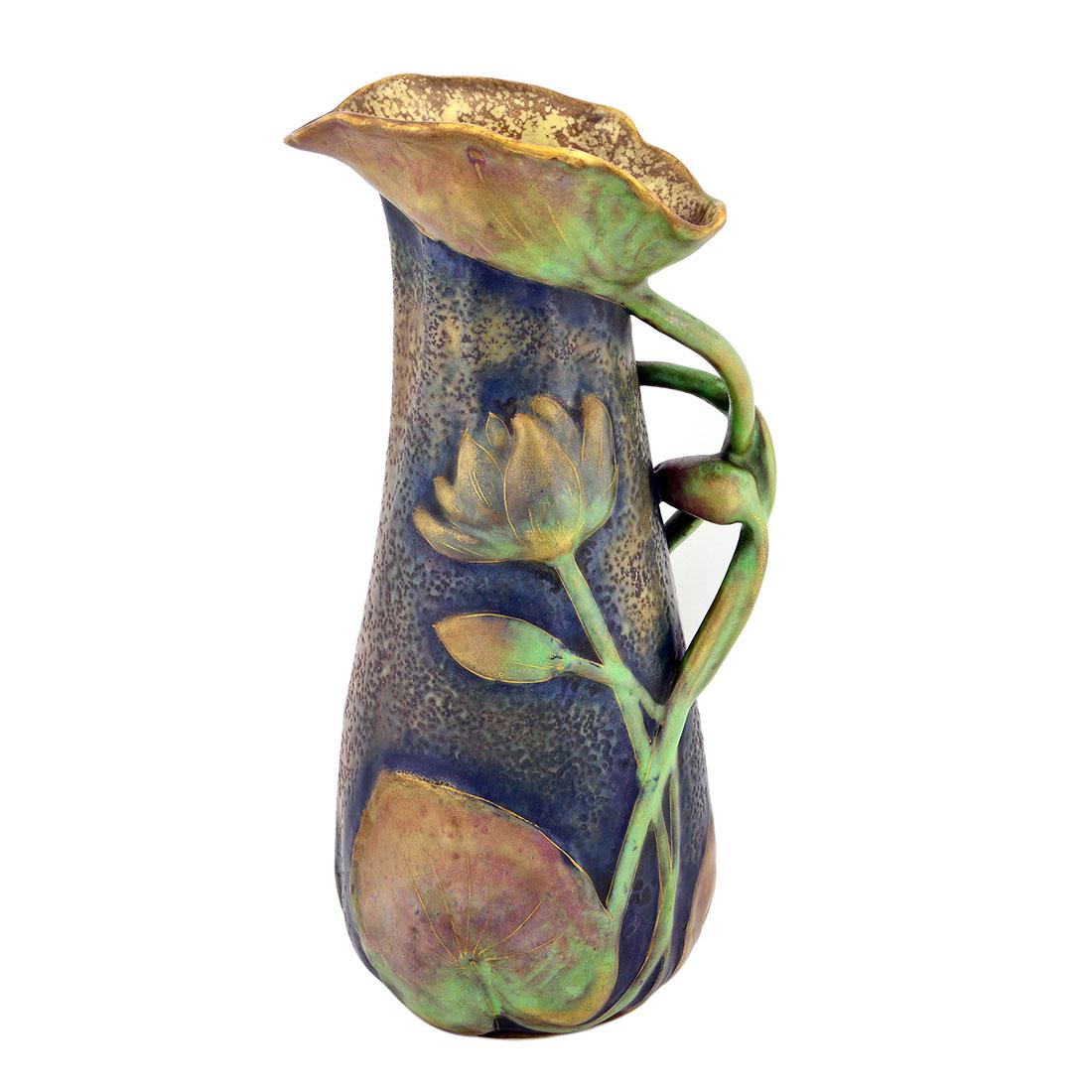 Amphora luster pitcher, lotus stems, leaves,pods,12 1/2: Riessner & Kessel (Amphora) luster glaze pitcher with three dimensional lotus blossoms, stems and leaves done circa 1905. Impressed marks include Riessner & Kessel crown logo, shape 8856 65, Austria a