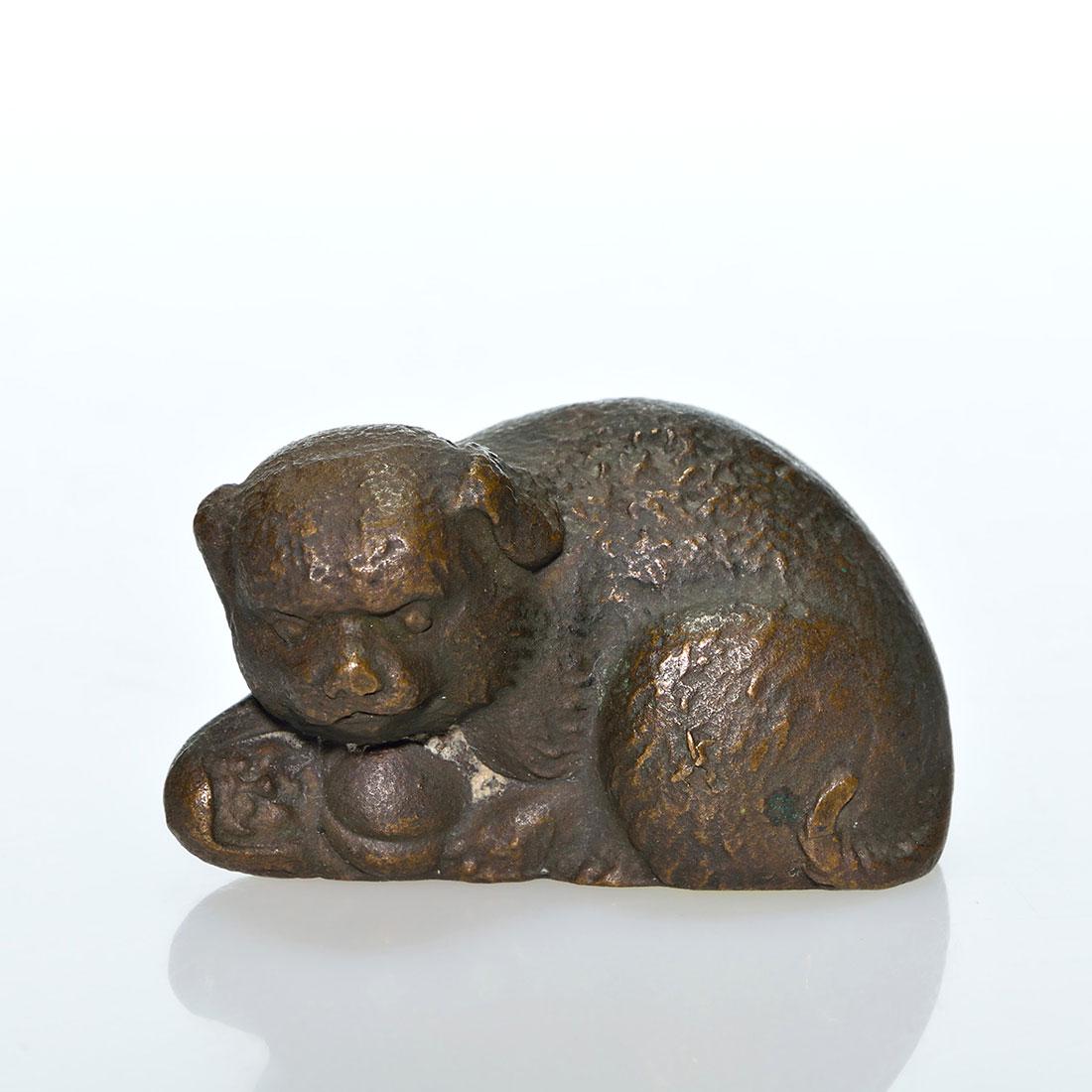Tiffany Studios Puppy & doll bronze paperweight, 1 1/2: Tiffany Studios bronze paperweight of a puppy cuddling a doll. Measures 1 1/2 inches by 2 3/8 inches long. Impressed Tiffany Studios, New York. Excellent condition.
