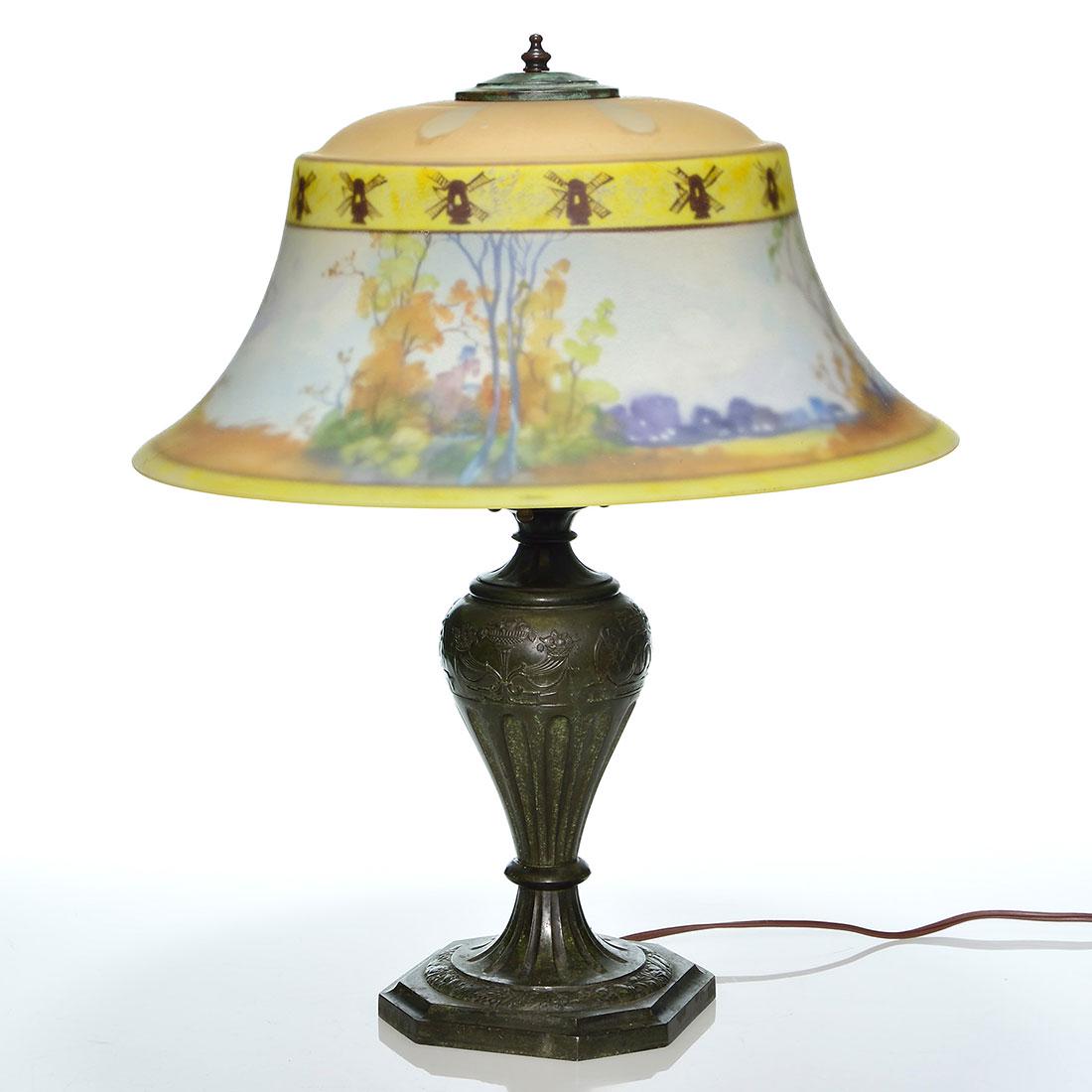 Pairpoint lamp, 17 1/4” scenic shade, both marked: Pairpoint lamp featuring a 17 1/4 inch Exeter shade reverse painted with a meadow of autumnal trees. Above the landscape windmills are painted upon a yellow band. Faintly stamped The Pairpoint Corp on