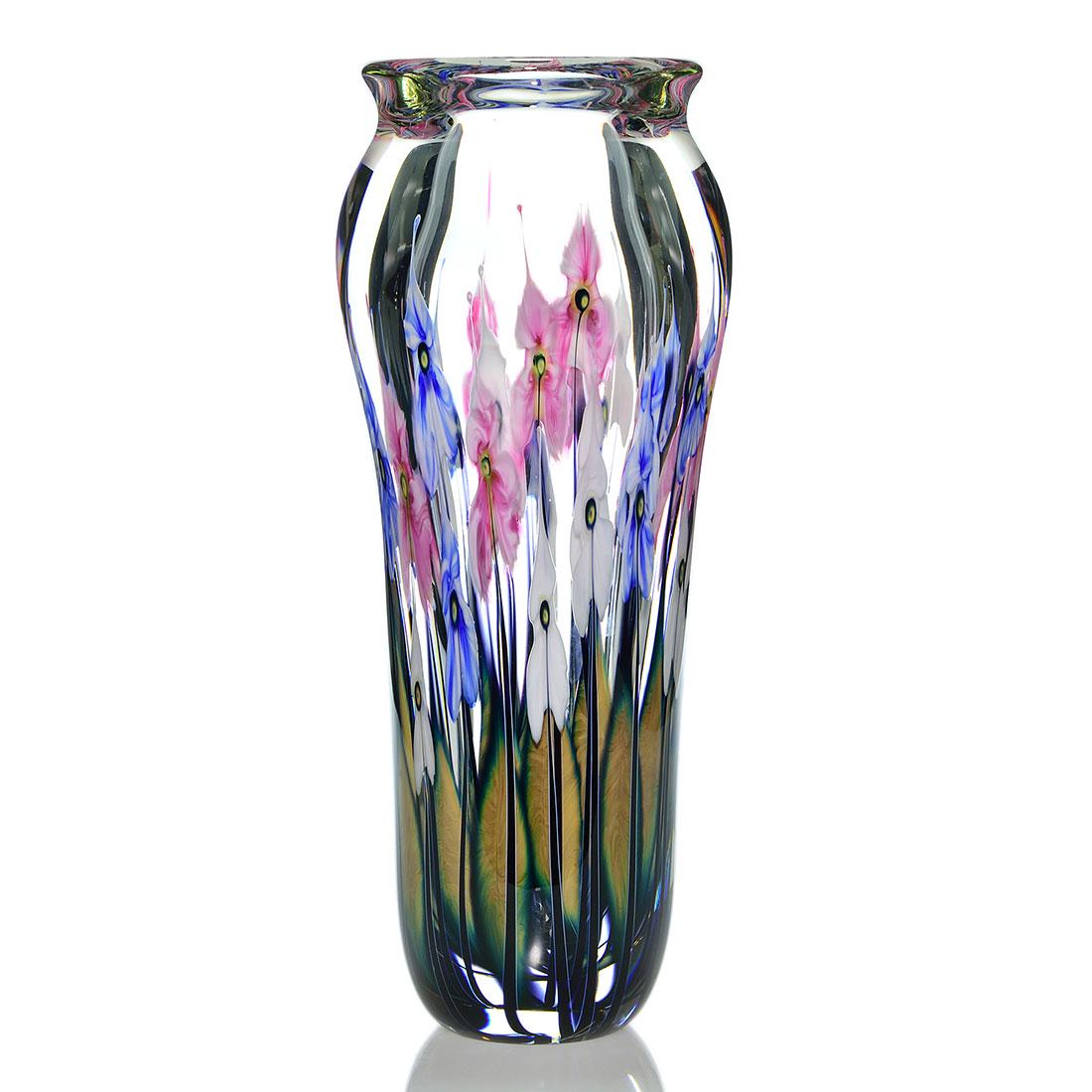 John Lotton Paperweight vase, 16 1/2”, patriotic: John Lotton Paperweight vase revealing four layers of patriotic flowers on tall black stalks backed by their much lower olive green foliage. Height is 16 1/2 inches and 7 1/2 inches across. Engraved J