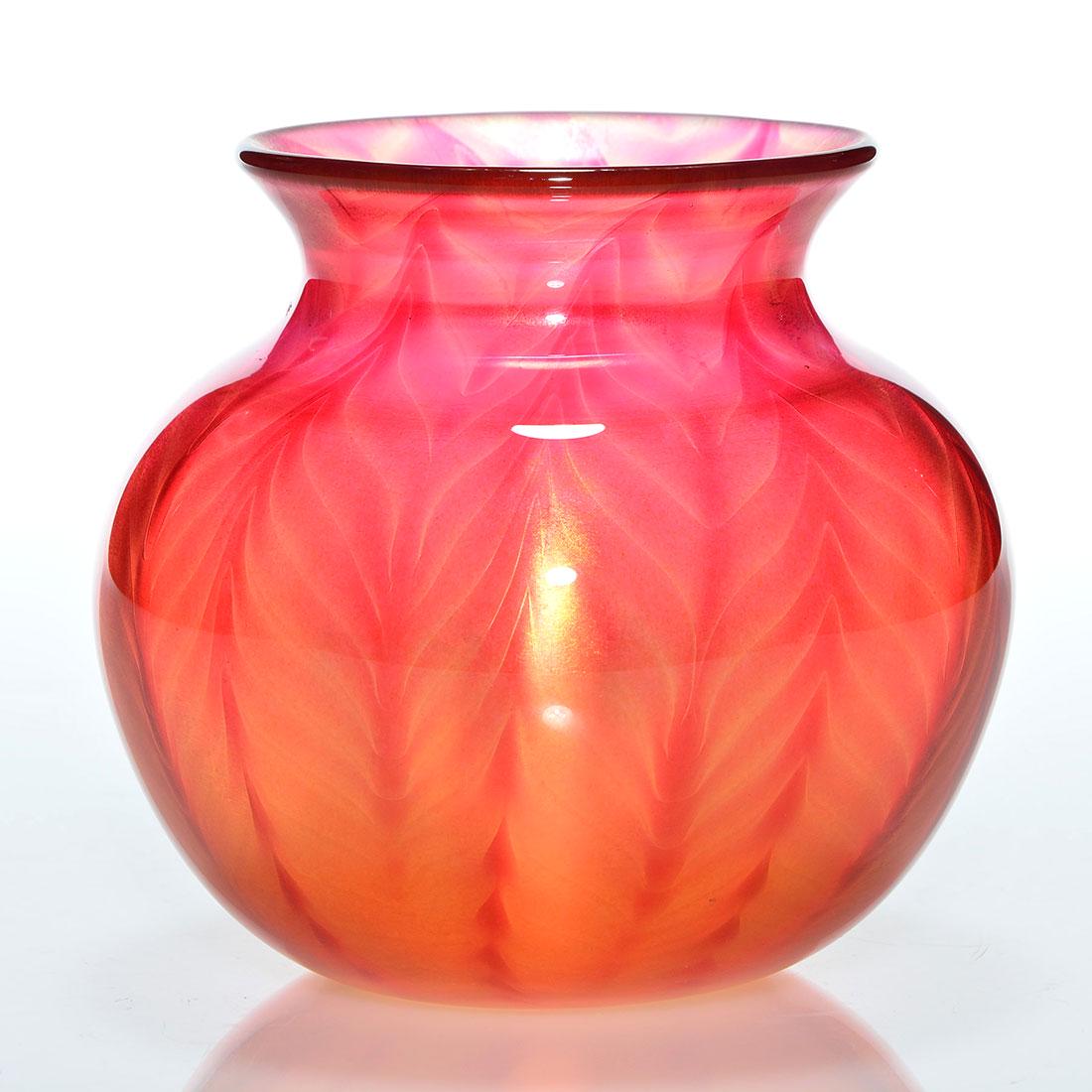 Early Daniel Lotton Sunset vase, red feathers, 5”: Early Daniel Lotton Sunset vase caressed by red feather decoration. Measures 5 inches tall and 6 inches across. Engraved with the artists signature and the 1986 year of creation. Pleasing coloration.