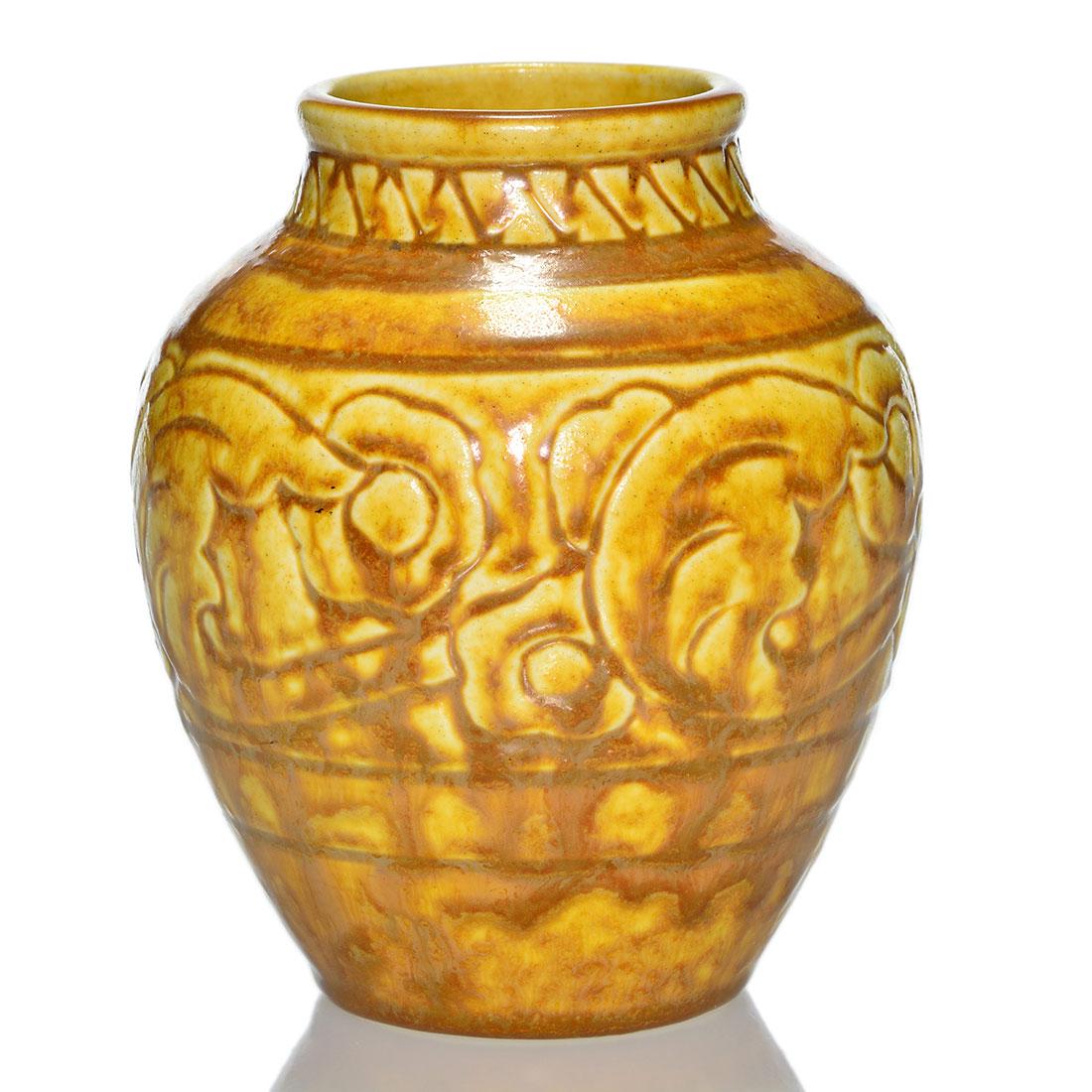 Rookwood production vase, floral, 1925, 2865, 5 1/2: Production vase with molded floral design cast in 1925 and covered with brown over yellow mat glazes. Marks include the Rookwood logo, date and shape 2865. There is light peppering throughout. Height