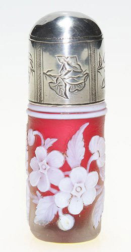 English cameo perfume, silver cap, 2 7/8": Diminutive English cameo perfume, attributed to Thomas Webb & Sons. The scarlet red bottle is decorated with a wreath of branched blossoms and foliage. The silver screw on cap is engraved with morning