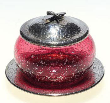 Marie Kirschner for Loetz, 4" jar, attribution: Sweetmeat container attributed to Marie Kirschner, artist for Loetz. The red glass having silver inclusions is combined with a silver plated cover and under tray. The silver plated pieces have pebbled