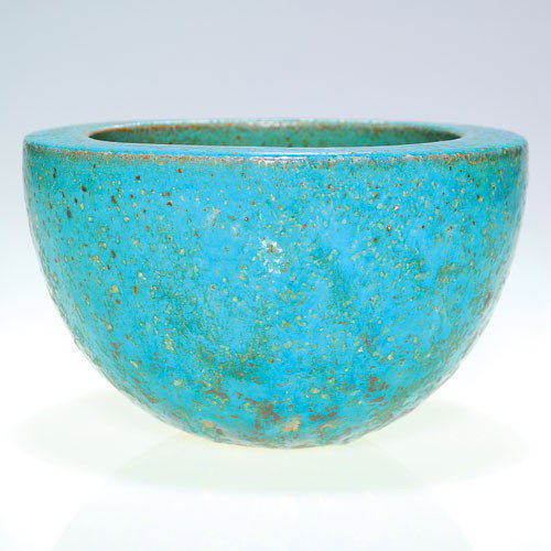 Natzler heavy bowl, slightly volcanic, blue, 4 1/8 by 6: Heavy bowl with blue, slightly volcanic glaze done by Gertrude and Otto Natzler. The glaze is near turquoise in color with brown, black and gray spots or metallic crystals. Signed NATZLER on the red c