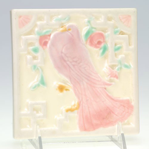 Rookwood Trivet, dove, 1930, shape 3124, 5 5/8" square: Tea tile depicting a pink pigeon in front of a trellis with pink roses. Impressed with the Rookwood logo, the 1930 date and shape 3124. No crazing with minor peppering and a small corner chip to a low