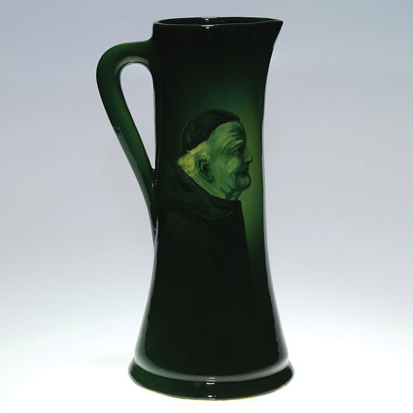 Zanesville Art Pottery La Moro tankard, monk: Tall Zanesville Art Pottery LaMoro tankard with a profile of a fat monk done in predominantly green. Impressed LaMoro on the bottom. Height 15 3/8 inches. Faint overall crazing. Good artwork and condi