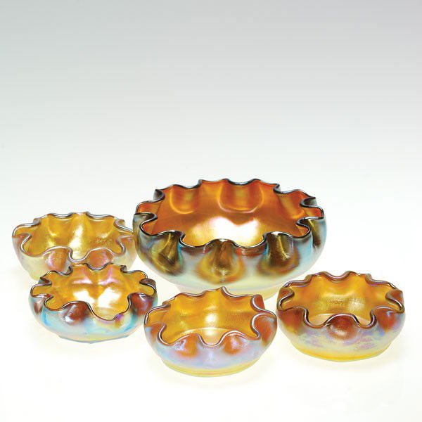 Tiffany master salt+4 individual salts, gold, 1 3/: Tiffany master salt bowl complete with four individual salt cellars. The master salt measures 1 3/4 inches by 4 inches. The smaller salts measure 1 inch by 2 1/2 inches. The set are iridescent gold ha