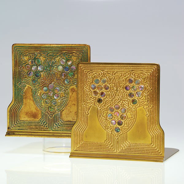 Pr Tiffany "Abalone" bookends, gilt bronze, 5 3/8": Nice pair of Tiffany Studios gilt bronze "Abalone" bookends exhibiting meandering grape vines in Art Nouveau fashion, the fruit ensconced with colorful mother of pearl shell. Height 5 3/8 inches. Impr