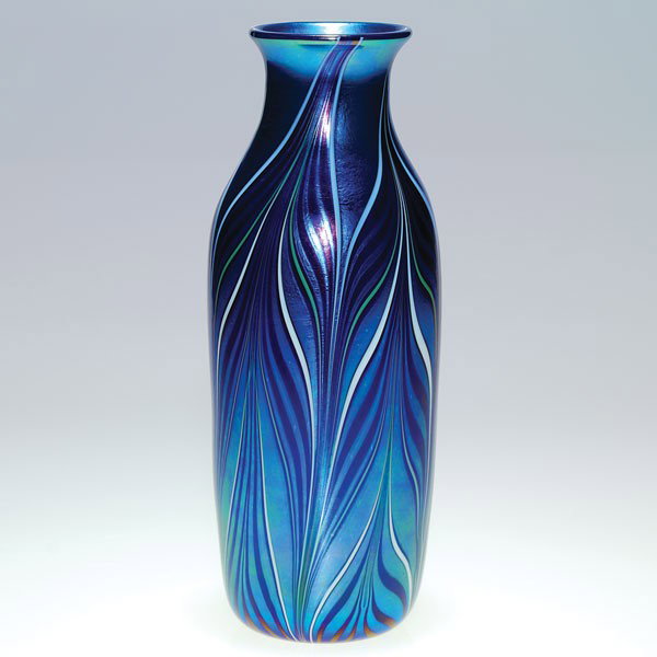 Orient & Flume slender vase, blue, 10 1/8", '81: Slender Orient & Flume vase in iridescent blue with a of elongated feather in royal blue with white tips. Height 10 1/8 inches. Company signature plus the '81 date and AK151 below the base. Fashionabl