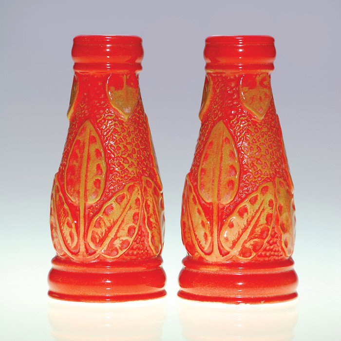 Pair Cowan candlesticks, leaves, red, tan, 6 1/4": Pair of Cowan candlestick lamp vases, a dual purpose creation attributed to Waylande Gregory and covered with an orange high glaze with tan highlights. Each is impressed with the circular Cowan logo. 