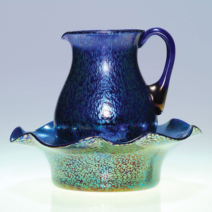 Loetz Czechoslovakia "oil spot" pitcher & bowl: Loetz Czechoslovakia 6 3/4 inch pitcher accompanied by a 3 inch by 10 inch ruffled bowl. The two share the same "papillon" design spread across cobalt glass. The bowl has a pretty aurene blue interior