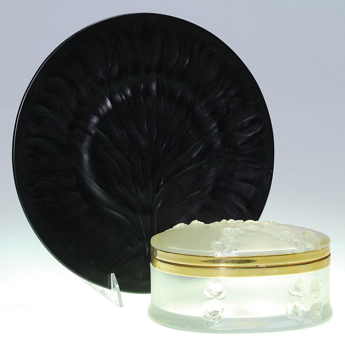 2 Lalique: black Algues plate + Coppelia "Roses": Two Lalique items: An ebony black "Algues" plate with a noble tree with spreading branches dominating the front. Signed "Lalique France"on the back. A Coppelia frosted oval dresser box with roses rais