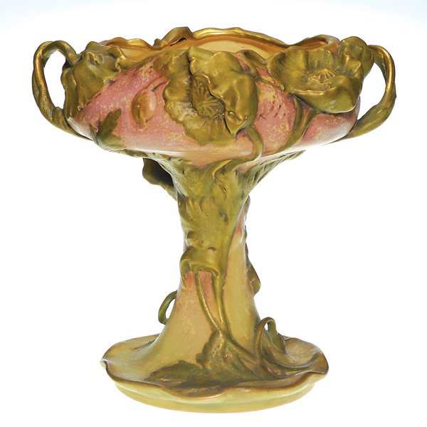 Art Nouveau Amphora compote, poppies, 11 1/2”: Large Amphora compote with three dimensional poppies in gilt finish. Stems extend away from the body, giving the appearance of handles . Stamped “Amphora Austria” on the bottom. Height 11 1/2 inch