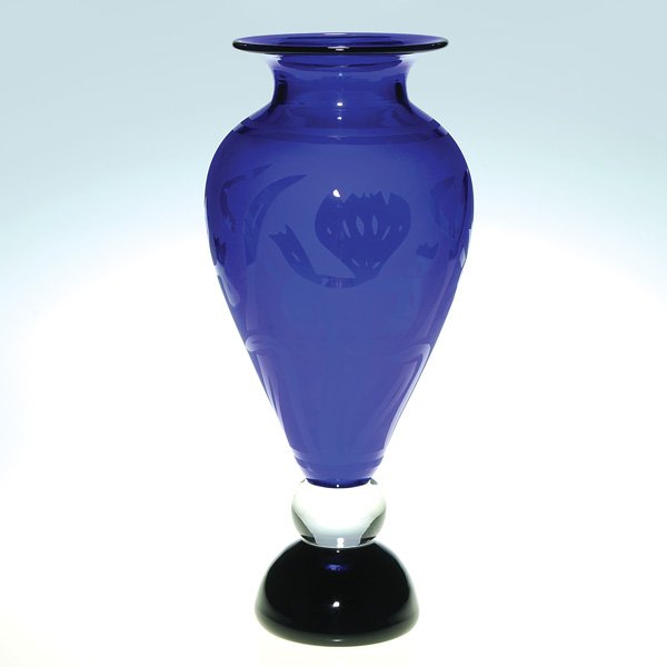 Corriea cobalt vase, sand blasted design, 13 3/4”: Corriea cobalt blue vase with stalks of irises and foliage sand blasted onto the surface, creating a nice glossy and matte-like finish and steadied by a clear ball and ebony base. Height 13 3/4 inches