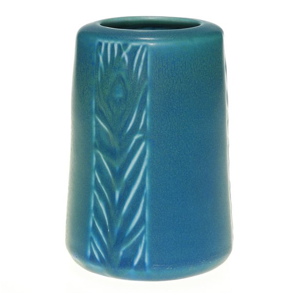 Rookwood mat production 5 1/8” vase, 1919: Production vase with a trio of panels, each containing a peacock feather, cast in 1919 and covered with a good dark blue mat glaze. Impressed with the Rookwood logo, the date and shape 1902. Uncrazed