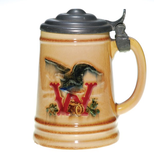 Rookwood 4 3/4” mug, Wiedemann Brewery: Commercial ware mug made for the Wiedemann Brewery covered with the Wine Madder glaze, the eagle colored in black and the W, symbol of the brewery, colored in red, and enhanced with a pewter lid. Impr
