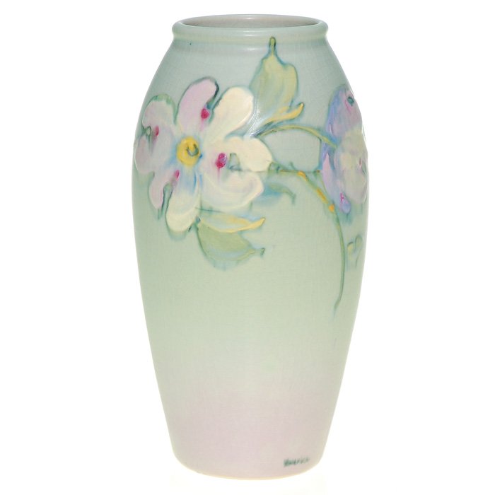 Weller Hudson vase, dogwood, 6 7/8”, signed.: Weller Hudson vase displaying an open dogwood flanked by two buds with the obscured signature of the artist at the baseline. Height 6 7/8 inches. Weller Ware mark beneath. Crazed and a yellowish area 