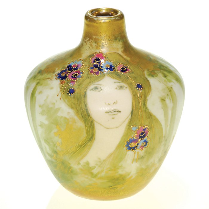 Amphora Maiden in the Woods vase, 4 1/2”: Turn Teplitz Amphora vase with the portraiture of a “Maiden in the Woods”, the beauty having pink and blue flowers enameled in her hair. Burnished gold highlights the trees, rim and base. Height 4