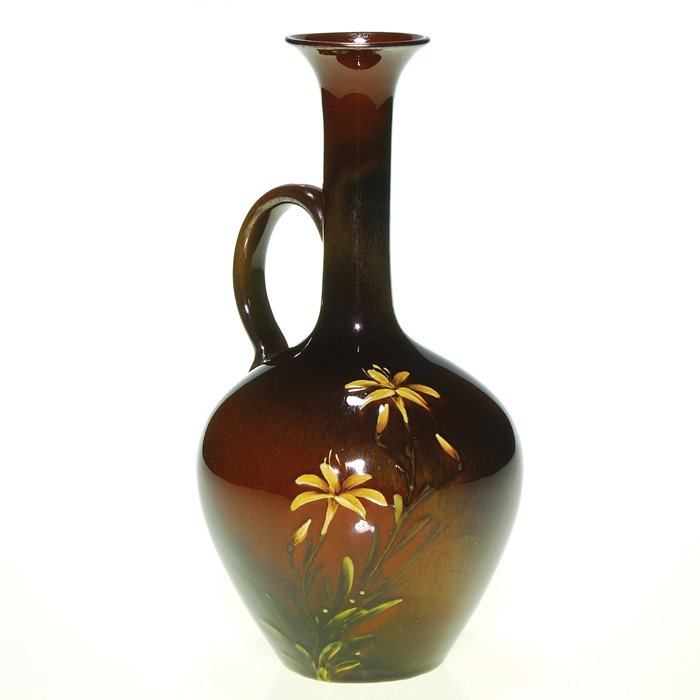 Rookwood Mahogany jug, lilies,MAD,'86, Tiger Eye: Rookwood Mahogany glaze jug with yellow lily decoration done by Matt Daly in 1886. The yellow glaze over red clay has produced some minor Tiger Eye effect and some of the silver sheeting associated wi