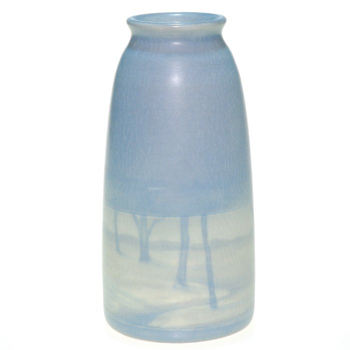 Rookwood Winter scenic, Wildman, 1912, 6 1/2”: Scenic Vellum vase decorated by Edith Wildman in 1912, by deploying a tonalistic winter scene with a stream between snow covered banks and fields and stark trees. Impressed with the Rookwood symbol, t