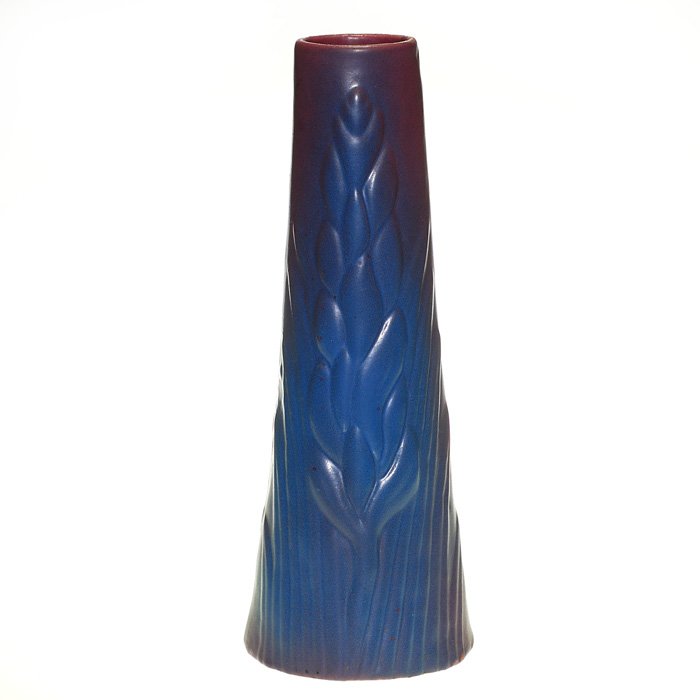 Van Briggle yucca vase, Mulberry glaze, 13 3/4”: Tall Van Briggle “Yucca” vase coated with their Mulberry glaze. Height 13 3/4 inches. The dirty bottom bears the company’s name and logo incised beneath. Good mold and color. Excellent condition