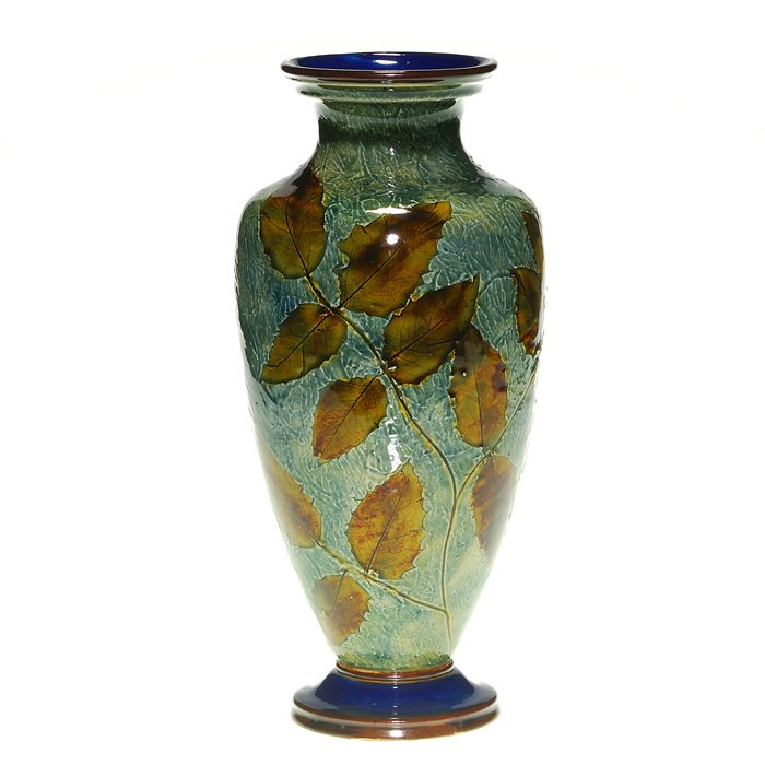 Royal Doulton Foliage Ware vase, 12”, marked: Large Royal Doulton “Foliage Ware” vase with nicely glazed actual leaf impressions. Height 12 inches. Impressed with the company’s lion, crown and circular logo and 6768 and incised “MB” mon