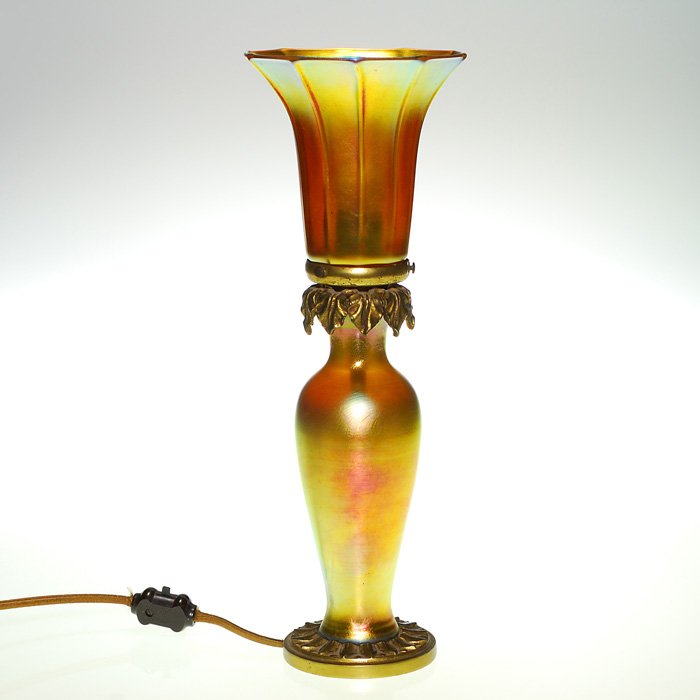 Steuben boudoir lamp, Quezal shade, 14 1/2”, signed: Steuben boudoir lamp base combined with a Quezal morning glory shade. Height 14 1/2 inches. The shade is engraved “Quezal” on the fitter. The lamp fittings appear original. Excellent condition.