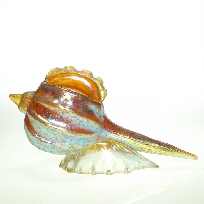 Loetz Candia Papillon conch shell, 5 3/4”X11 7/8”: Good Loetz Candia Papillon conch shell surfing a wave. Height 5 3/4 inches, the length being 11 7/8 inches. Nice defined ribbing with a good pattern displaying blue highlights and a hint of magenta.