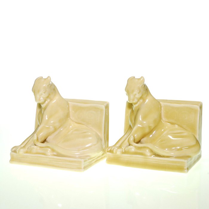 Rookwood pair Panther bookends, 1945, 5 1/2”: Pair of Rookwood Panther bookends cast in 1945 and covered in a tan high glaze. Marks include the Rookwood logo, date, shape 2564 and the cast monogram of the designer, William McDonald. Height 5 1/2 